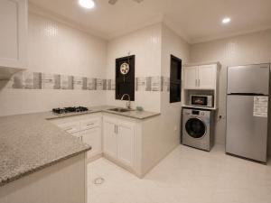 a large kitchen with a refrigerator and a dishwasher at hotel Alsalam suites in Salalah