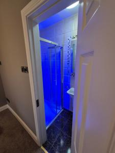 a bathroom with a shower with blue lighting at Central House Kenmare in Kenmare +16 photos