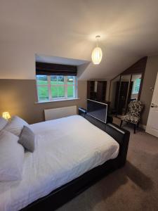 a bedroom with a large white bed and a window at Central House Kenmare in Kenmare