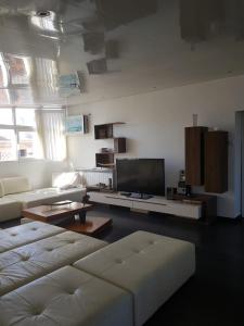 a living room with a couch and a flat screen tv at le jasmin in El Achour