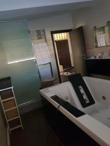 a bathroom with a bath tub and a sink at le jasmin in El Achour