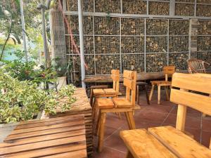 a patio with wooden benches and a table and chairs at Côn Đảo Home in Con Dao +11 photos