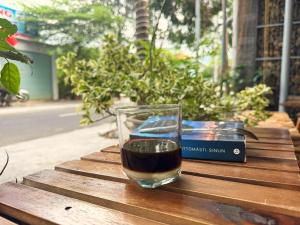 a glass of wine sitting on a table next to a book at Côn Đảo Home in Con Dao