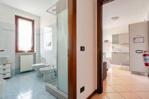 a bathroom with a toilet and a glass door at Appartamento Manerbio in Manerbio