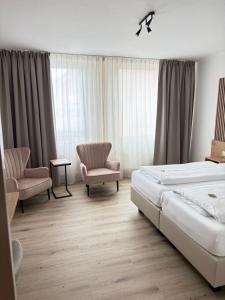 a hotel room with a bed and two chairs at Hotel Flensburger Hof in Flensburg