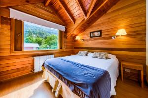 a bedroom with a bed in a wooden room at Del Sauco Apart & Spa in San Martín de los Andes +56 photos