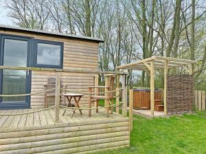 a wooden cabin with a picnic table and a gazebo at The Rams Rest - Uk48823 in Kirby Misperton
