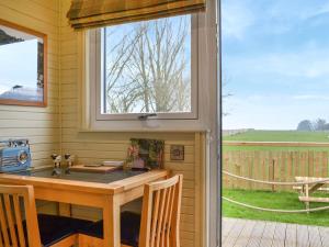a table in a screened in porch with a window at The Rams Rest - Uk48823 in Kirby Misperton
