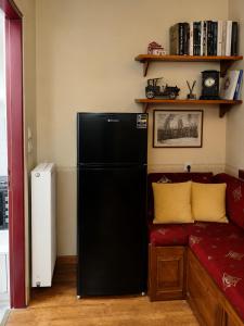 a black refrigerator in a room with a red couch at Villa Georgia in Vitsa