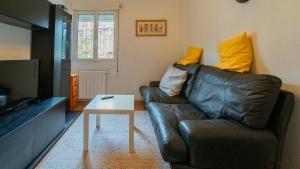 a living room with a leather couch and a coffee table at Monte la Torre in Santander