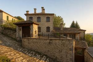 an old stone house with a brick wall at Villa Georgia in Vitsa