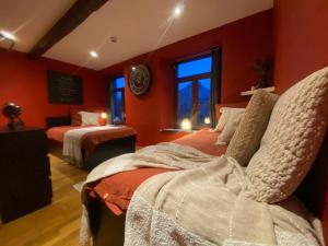 a bedroom with two beds with red walls at La Forge - Chambres d'hôtes en Ardenne in Wellin +46 photos