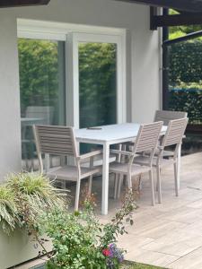 a white table and chairs on a patio at VILLA LIDO - Lake Como in Colico