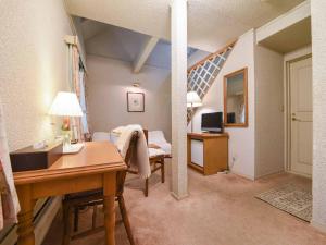 a living room with a desk and a room with a bed at Country Inn Orchard House in Hokuto