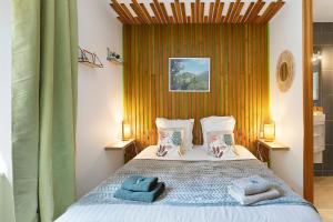 a bedroom with a bed with blue towels on it at Le Clos D'audio in Riols
