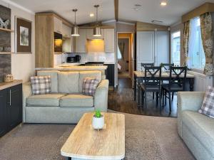 ein Wohnzimmer und eine Küche mit Sofa und Tisch in der Unterkunft Maple 8 in Filey