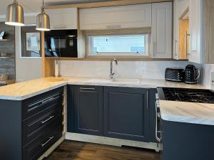 eine Küche mit blauen Schränken und einer Spüle in der Unterkunft Maple 8 in Filey