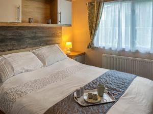 ein Schlafzimmer mit einem Bett, auf dem ein Tablett mit Essen steht in der Unterkunft Maple 8 in Filey