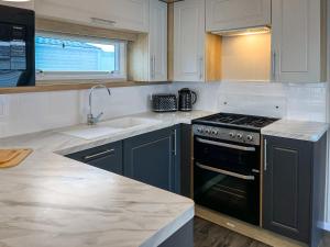 eine Küche mit Spüle und Herd Oberer Backofen in der Unterkunft Maple 8 in Filey