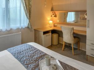 ein Schlafzimmer mit einem Bett und einem Schreibtisch mit Stuhl in der Unterkunft Maple 8 in Filey + 6 Fotos