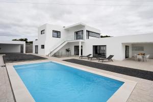 a white house with a swimming pool in front of it at Bella Casa - piso inferior in Angra do Heroísmo