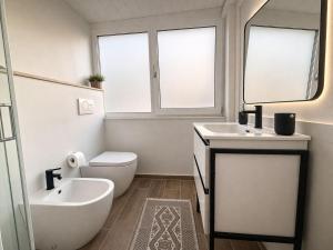 ein Badezimmer mit Badewanne, Toilette und Waschbecken in der Unterkunft Lilly Rooms in Codaruina
