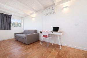 ein Zimmer mit Schreibtisch, Stuhl und Computer in der Unterkunft Lilly Rooms in Codaruina
