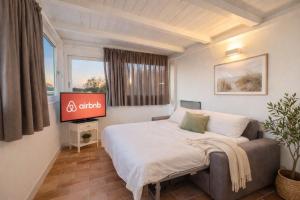 ein Schlafzimmer mit Bett und Flachbildfernseher in der Unterkunft Lilly Rooms in Codaruina