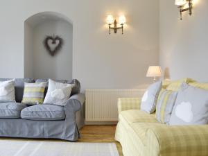 a living room with two couches and a heart on the wall at The Old School House Cottage in Coupar Angus