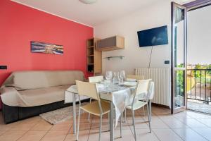 a dining room with a table and chairs and a couch at Appartamento Manerbio in Manerbio