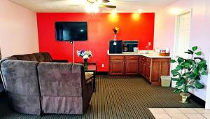 a living room with a couch and a red wall at Rama Inn Bells - Jackson West Hwy 412 in Bells