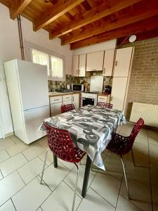 a kitchen with a table with chairs and a refrigerator at Le Gite Zelya in Bourbourg