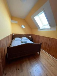 a bedroom with a large bed with a skylight at Le Gite Zelya in Bourbourg