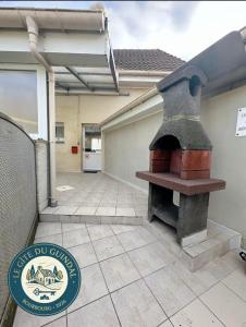 a patio with an outdoor oven in a house at Le Gite Zelya in Bourbourg +10 photos