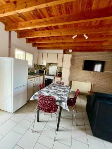 a kitchen with a table and chairs and a refrigerator at Le Gite Zelya in Bourbourg