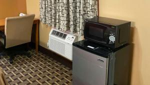 a room with a tv on top of a refrigerator at Rama Inn Bells - Jackson West Hwy 412 in Bells +15 photos