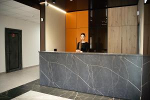 a man standing behind a counter in a lobby at Готель Бутік Сіті in Kropyvnytskyi