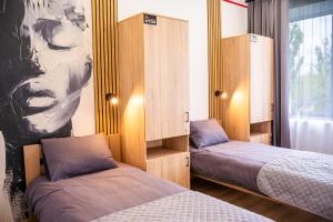 a bedroom with two beds and a painting of a woman at Готель Бутік Сіті in Kropyvnytskyi +37 photos