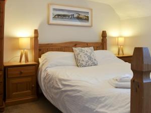a bedroom with a bed with two night stands and two lamps at Old Town Cottage in Sidmouth