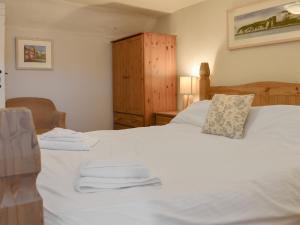 a bedroom with a white bed with towels on it at Old Town Cottage in Sidmouth +16 photos