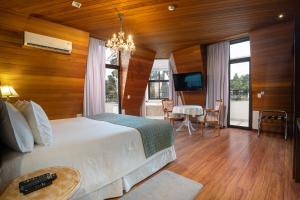 a bedroom with a bed and a dining room with a table at Pousada Luis XV in Campos do Jordão