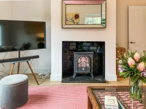 a living room with a fireplace and a table at Elm Tree House - Uk51762 in Landford