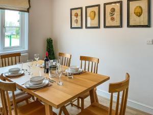 a wooden table with plates and wine glasses on it at Elm Tree House - Uk51762 in Landford