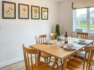 a dining room with a wooden table and chairs at Elm Tree House - Uk51762 in Landford +18 photos