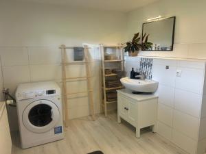 a bathroom with a washing machine and a sink at Kastanienidyll in Grabowhöfe