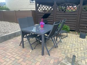 a blue table with four chairs and a vase of flowers at Kastanienidyll in Grabowhöfe