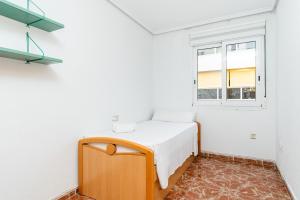 a small bedroom with a bed and a window at Sunrise Arts 2 in Torrevieja