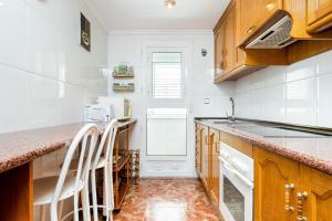 a kitchen with wooden cabinets and a counter top at Sunrise Arts 2 in Torrevieja +14 photos