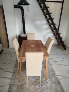 a wooden table and chairs in a room with a staircase at Vikendice Božić in Višnjićevo