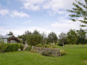 a garden with a stone wall in a yard at Grange Loft - Uk31594 in Dundee